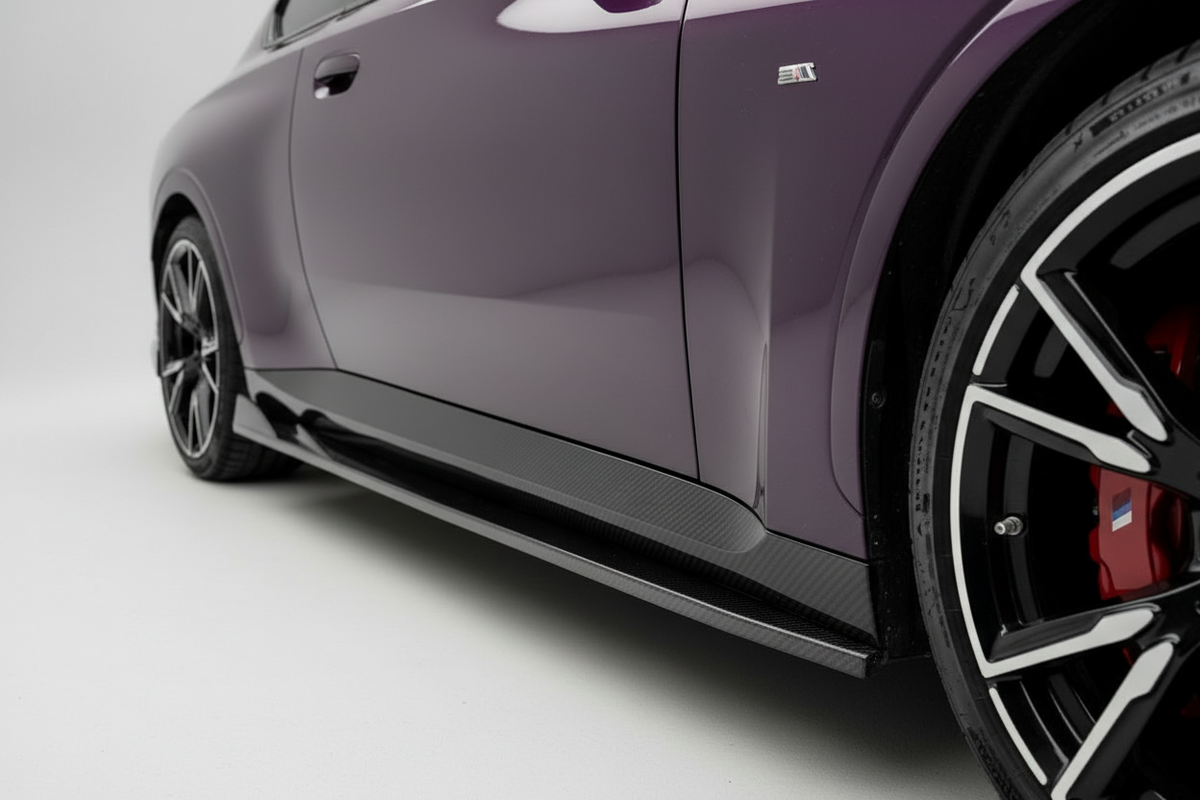 Close-up side view of a purple car showing a carbon fiber side skirt, black multi-spoke wheels, and red brake calipers on a white studio background.