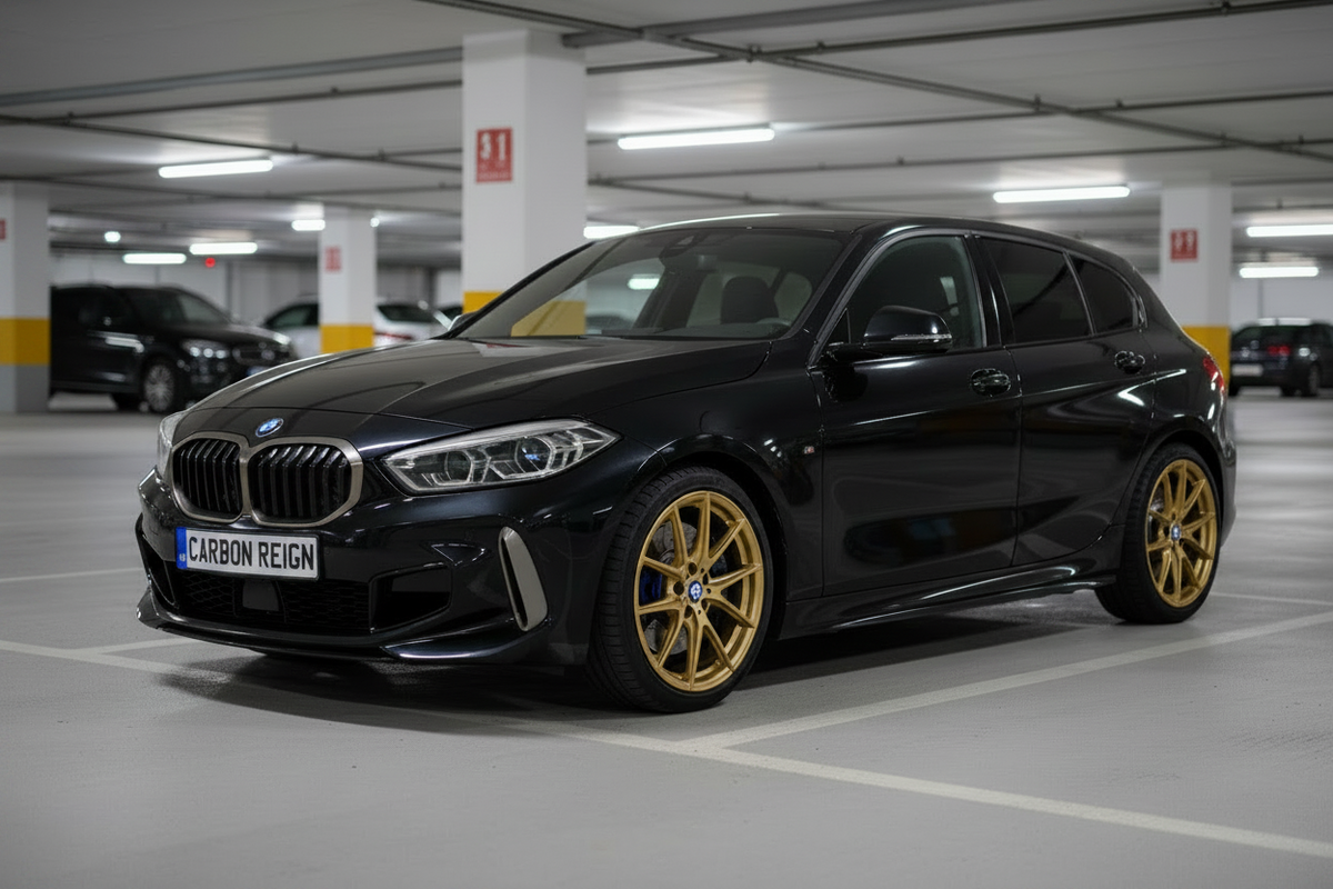 A black BMW 1 Series hatchback with gold multi-spoke wheels, parked in a modern indoor parking structure.