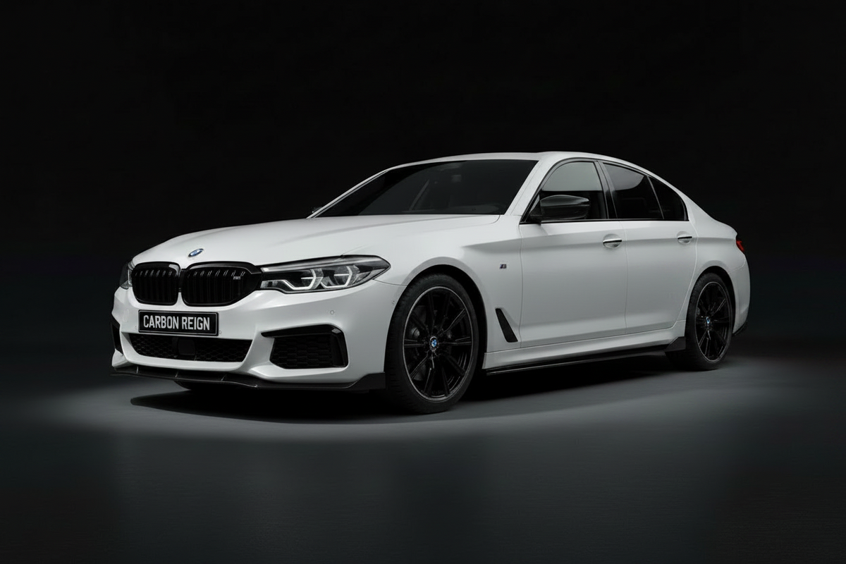 A white BMW 5 Series sedan with black wheels and a carbon-fiber front splitter, shown from a three-quarter angle against a dark studio background. A license plate reading 'CARBON REIGN' is mounted on the front bumper.