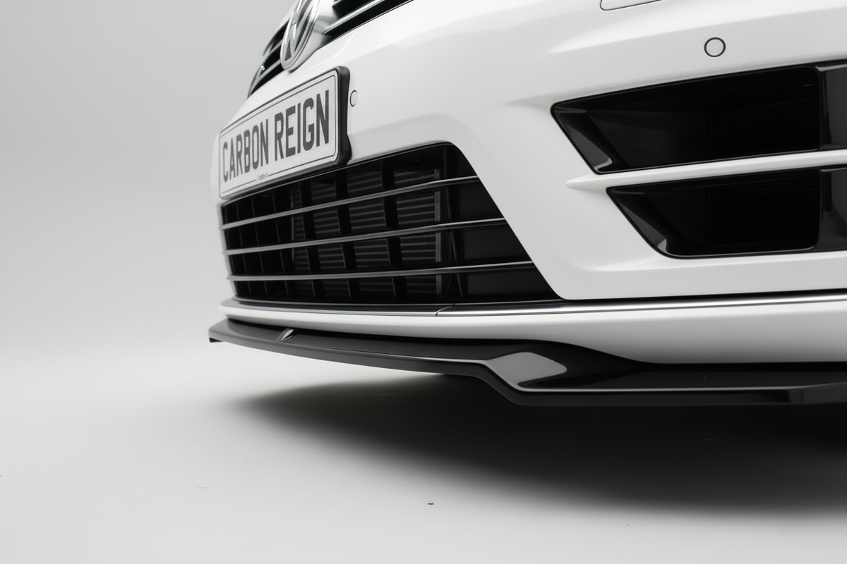 Close-up of the front bumper and lower grille area of a white car, showing a black carbon-fiber-style front lip splitter with a badge reading 'CARBON REIGN'.