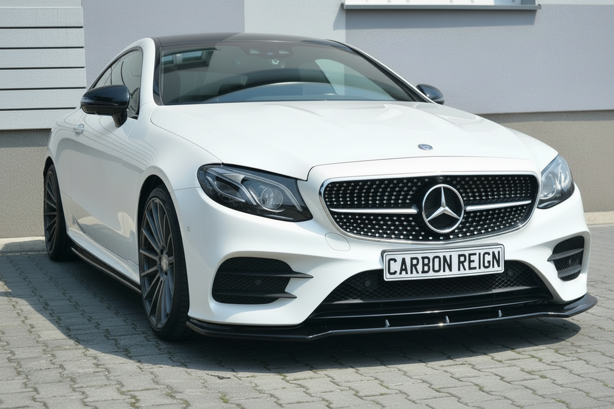 A white Mercedes-Benz C-Class coupe with a carbon-fiber pattern grille and a custom 'CARBON REIGN' license plate, parked on a paved driveway in front of a modern gray building.