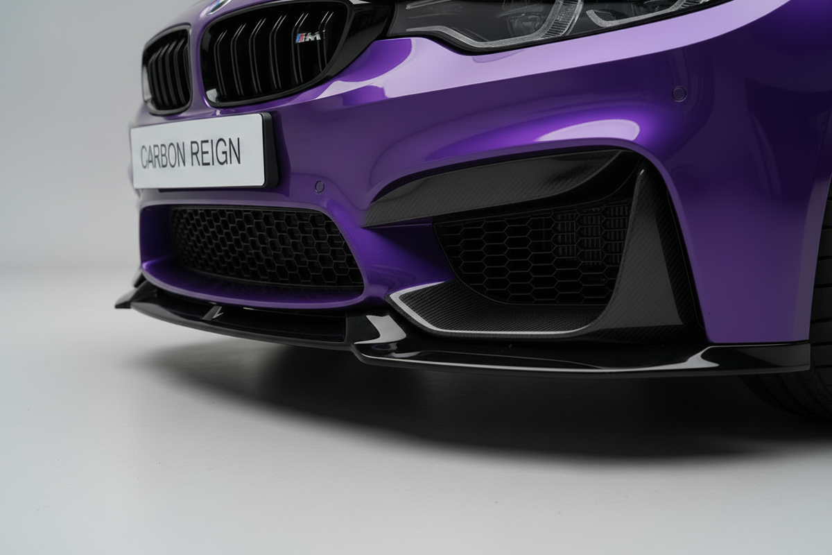 Close-up of the front bumper and lower grille area of a purple car, showing black carbon-fiber-style aerodynamic components and a badge that reads CARBON REIGN.