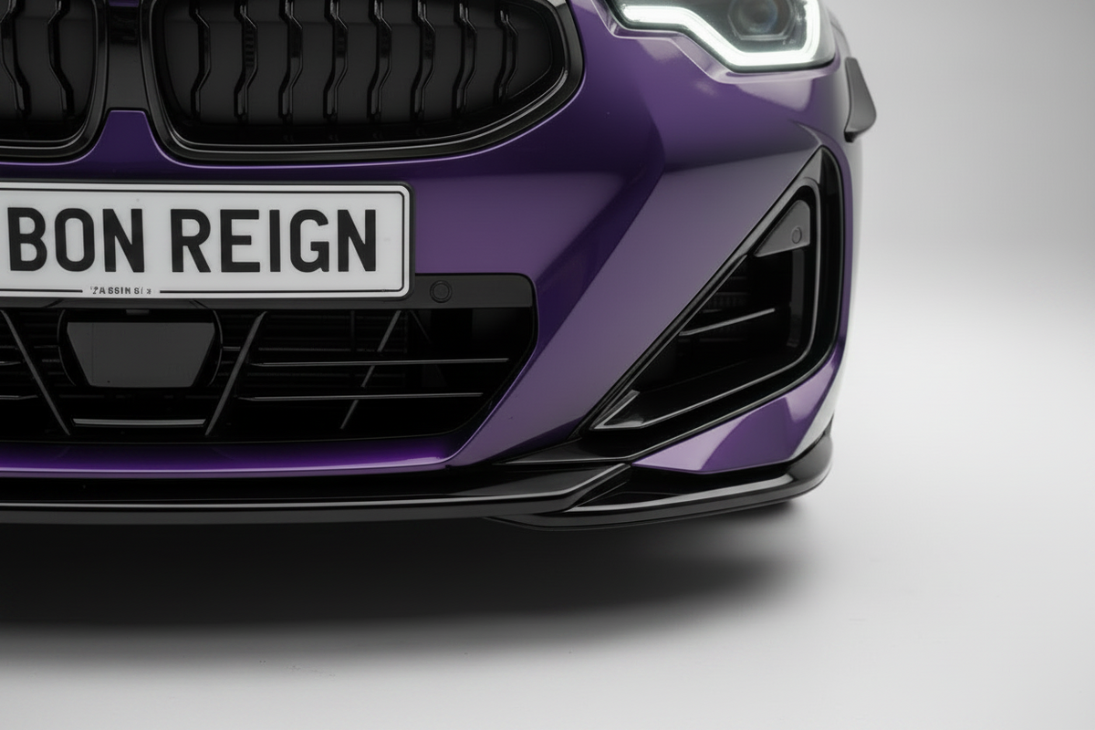 A front-facing studio shot of a purple BMW sedan with a custom 'CARBON REIGN' license plate, set against a seamless light gray background.